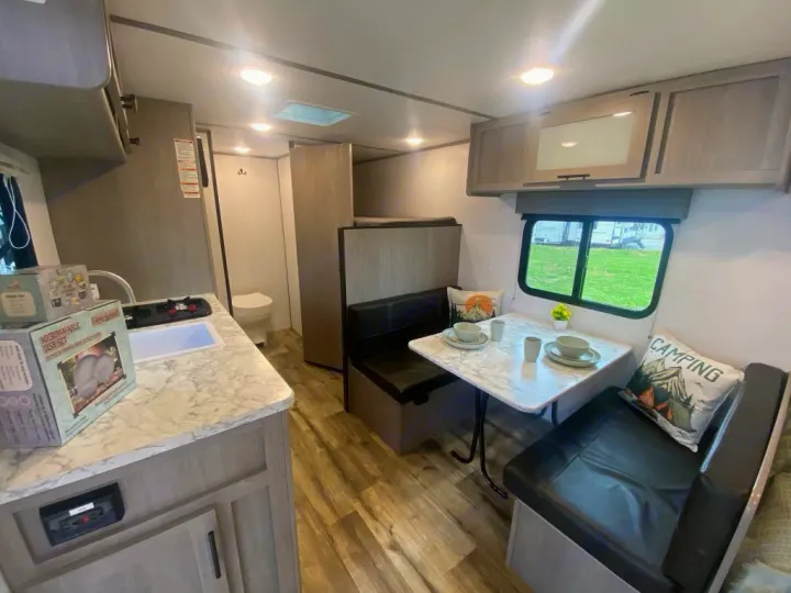 Inside a comfortable **rv rental**: a well-appointed kitchen, cozy dinette, and bathroom. Your mobile home away from home.. Dutchmen Coleman 2024