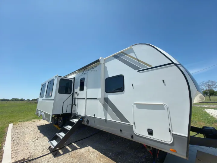 Bright, sunny day showcasing a white Roamer Open Range travel trailer RV rental, with steps extended, ready for adventure.. Highland Ridge RV Open Range Roamer 2026