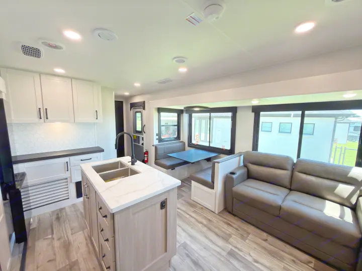 Modern RV rental interior with a spacious kitchen island, comfortable dinette, and living area. Perfect for travel!. Highland Ridge RV Open Range Roamer 2026
