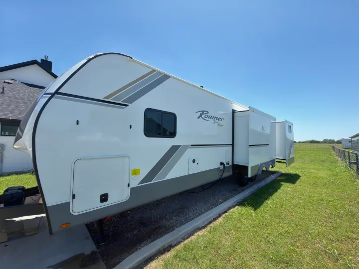 This Roamer Open Range RV rental, with its slide-out extended, is ready for a sunny camping or travel adventure.. Highland Ridge RV Open Range Roamer 2026