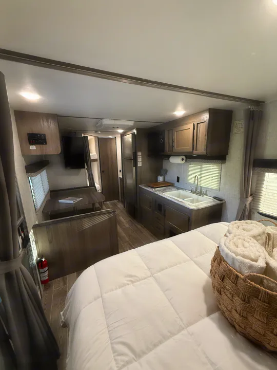 Cozy rv rental interior featuring a kitchen, dining area, and bedroom, perfect for a comfortable getaway.. Gulf Stream Ameri-Lite 2021