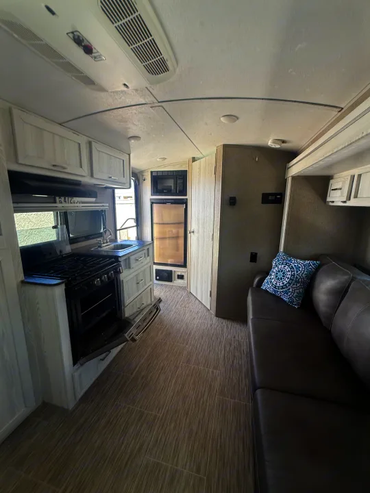 Modern RV rental interior with kitchen (stove, microwave, fridge) and comfy sofa. Perfect for your next road trip!. Forest River Flagstaff E-Pro 2018