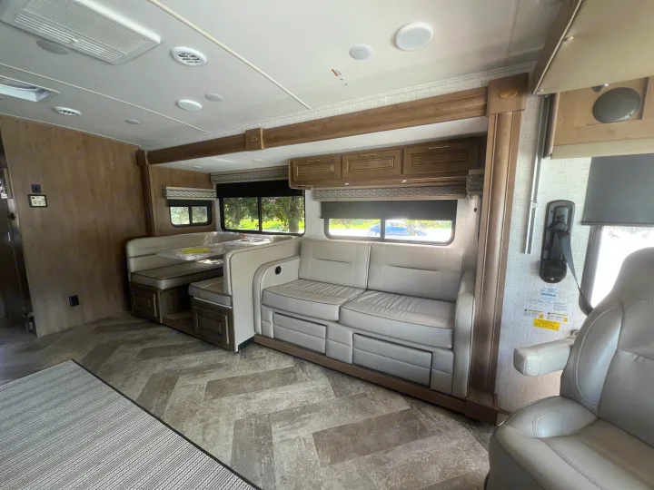 Spacious RV rental interior featuring a bright dinette, comfy sofa, and modern ceiling details, ready for travel.. Georgetown GT3 2020
