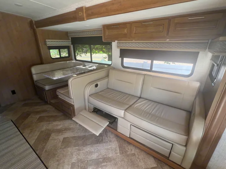 Spacious RV rental interior with a cozy dinette, reclining sofa, and overhead storage, perfect for your next adventure.. Georgetown GT3 2020