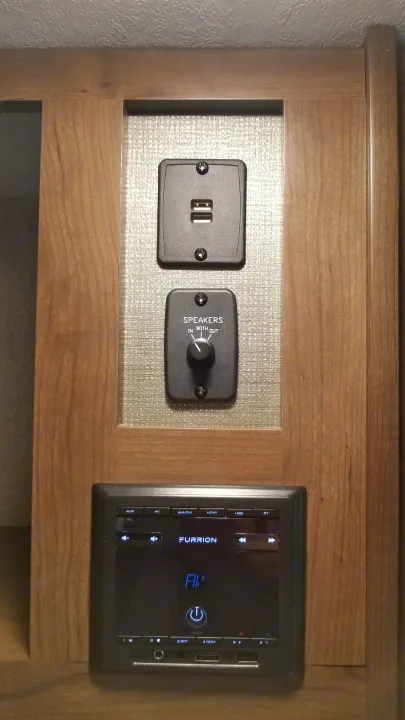 RV rental entertainment system: Furrion stereo, USB ports, and a speaker selector for 'in', 'both', or 'out' zones.. Keystone RV Passport Ultra Lite 2019