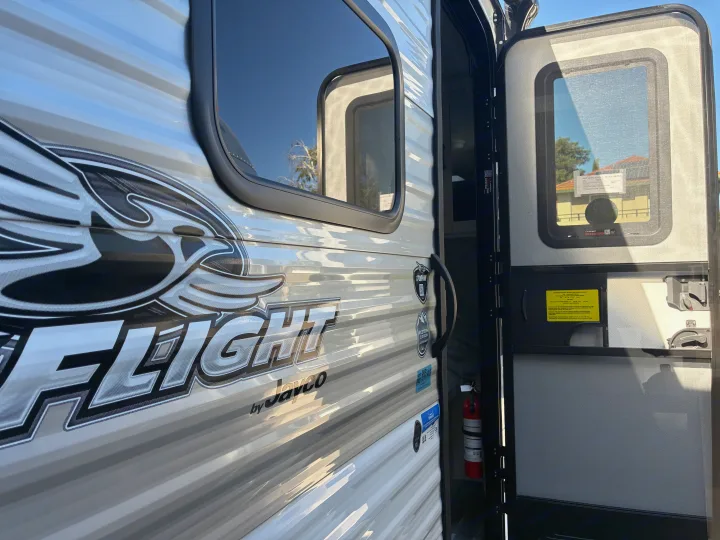Jayco Flight RV rental: exterior view with open door, revealing the interior and a mounted fire extinguisher.. Jayco 1UJBC0AJ6F7750334 2026