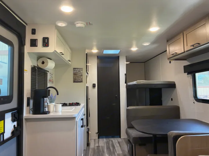 Modern RV rental interior with a fully equipped kitchen, cozy dining area, and bunk beds. Perfect for camping adventures.. Jayco 1UJBC0AJ6F7750334 2026