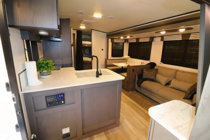 Spacious RV rental interior: modern kitchen, dining booth, comfy living area, and bunk beds in view.. Cruiser RV MPG Ultra Lite 2021