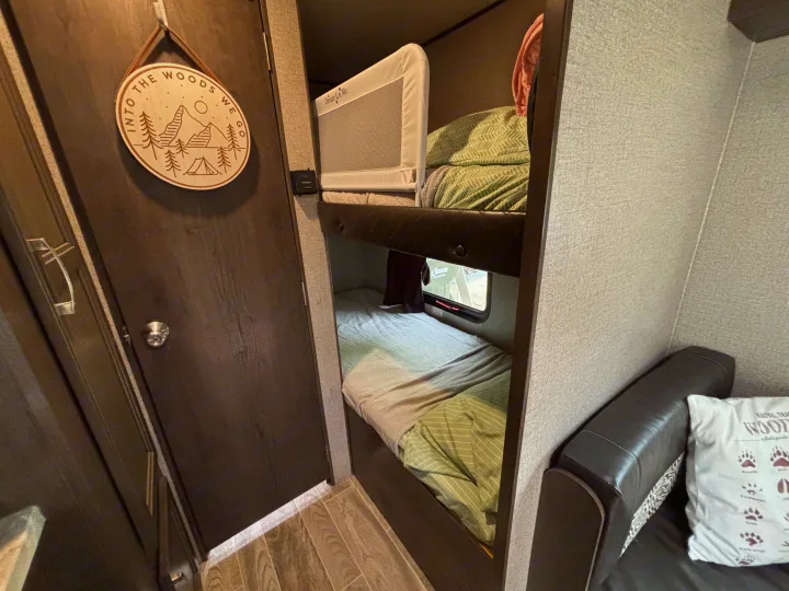 This rv rental offers cozy bunk beds with a 'Dream On Me' safety rail, 'Into The Woods We Go' decor, and a window view.. Jayco Jay Flight SLX 2021