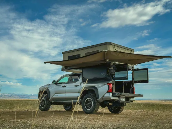 Silver Toyota Tacoma overland RV rental with rooftop tent and awning, ideal for remote camping adventures.. Toyota Tacoma 2026