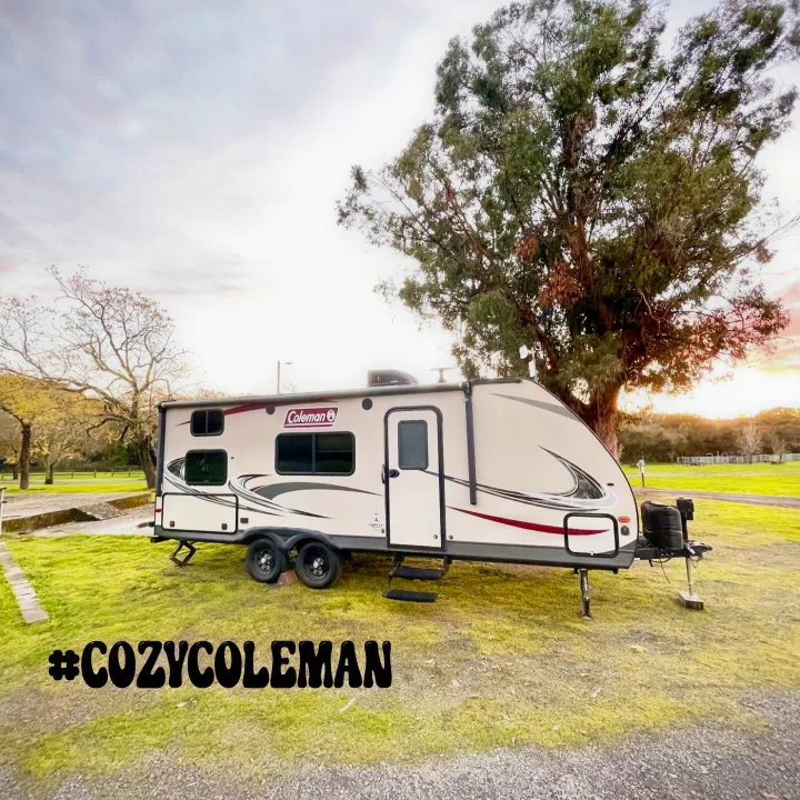 Experience comfort with this Coleman rv rental, parked at a grassy site. Ready for your cozy outdoor adventure!. Coleman Coleman Light LX Series 2125BH 2018