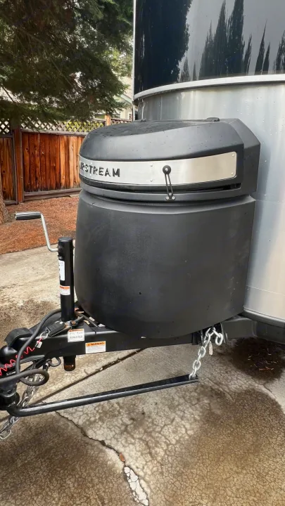 Front view of an Airstream travel trailer's hitch, propane tank cover, and jack. Ready for your next RV rental adventure.. Airstream Basecamp 2022