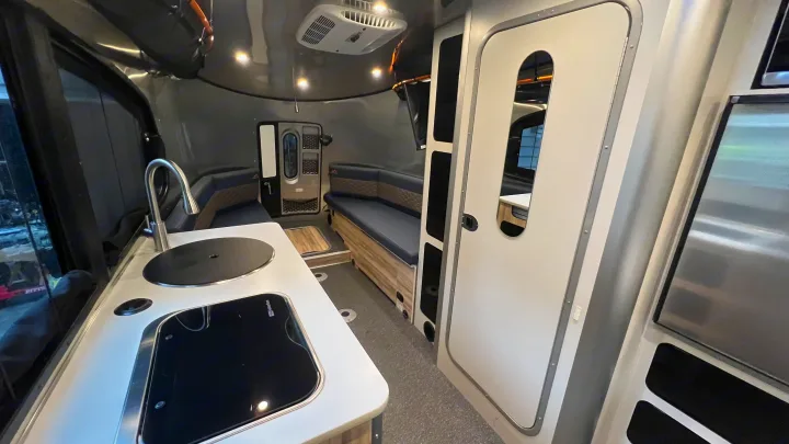 Step inside this sleek RV rental! Features a compact kitchen with a sink/stovetop, comfortable seating, and a modern interior.. Airstream Basecamp 2022