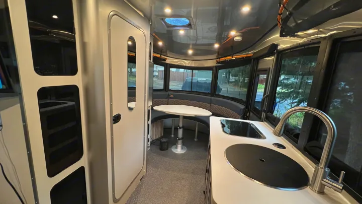 Step inside this RV rental's modern interior, featuring a well-equipped kitchen, comfortable dinette, and scenic windows for travel.. Airstream Basecamp 2022