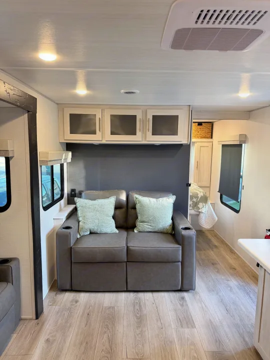 This RV rental offers a bright & modern living space with a comfy gray sofa, light wood-look flooring & overhead storage.. Forest River Unmapped 2026