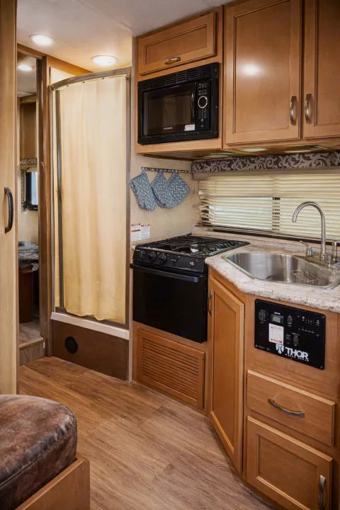 This cozy RV rental features a full kitchen with a microwave, stove, oven, sink, and shower, perfect for any adventure.. Thor Four Winds 2019