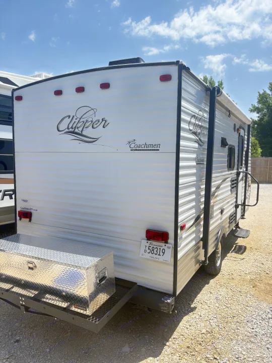 Rear view of a white Clipper Coachmen RV rental, a travel trailer with a rear storage box and Tennessee plate T58319.. Coachmen Clipper 17BH 2015