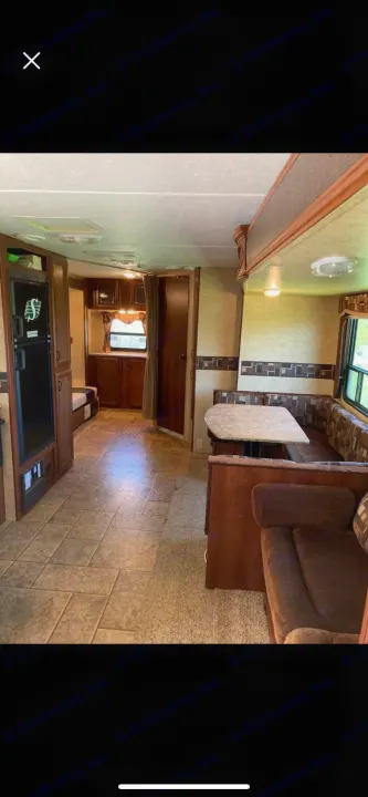 Inside an RV rental: a cozy living space with a dinette, sofa, kitchenette, and bedroom, ideal for travel adventures.. Forest River Tracer Executive 2010