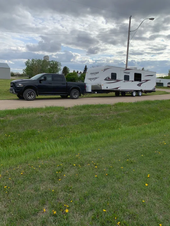 Black pickup towing a Tracer travel trailer, perfect for an rv rental adventure or scenic road trip.. Forest River Tracer Executive 2010