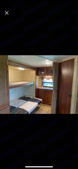This rv rental interior features a bunk bed area with a convertible lower bed, cabinets, and a window, ideal for families.. Forest River Tracer Executive 2010