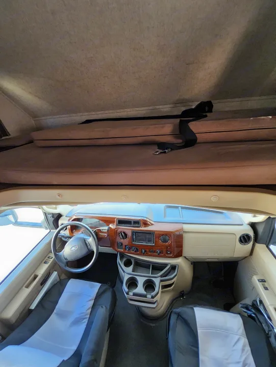 This RV rental features a spacious cockpit with a wood-trimmed dashboard, Ford steering wheel, front seats, and an overhead bunk.. Forest River Other 2018