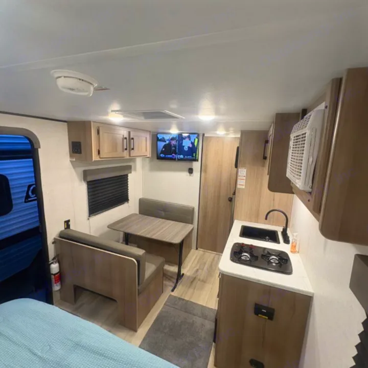 Step into this compact rv rental, featuring a modern kitchen, cozy dinette, comfortable bed, and TV for your travels.. Keystone RV Coleman 2025