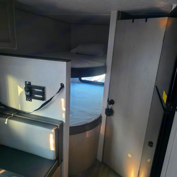 RV rental interior featuring comfortable bunk beds, a cozy dinette area, and a compact refrigerator, perfect for travel.. Clipper 5K 2024