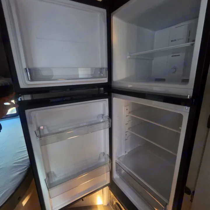 Spotless, empty two-door refrigerator in this RV rental. Ample shelves & door bins, ready for your travel essentials!. Clipper 5K 2024