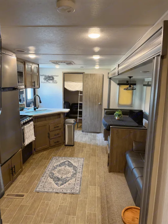 Spacious RV rental interior featuring a modern kitchen, comfortable dinette, and convenient bunk beds for adventure travel.. Forest River Palomino Puma 2021