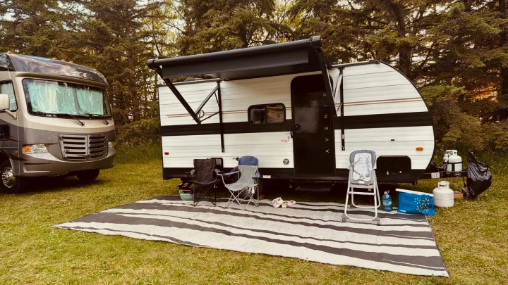 An RV rental campsite features a motorhome & an Avenir travel trailer set up for outdoor relaxation.. Cruiser RV Avenir 2024