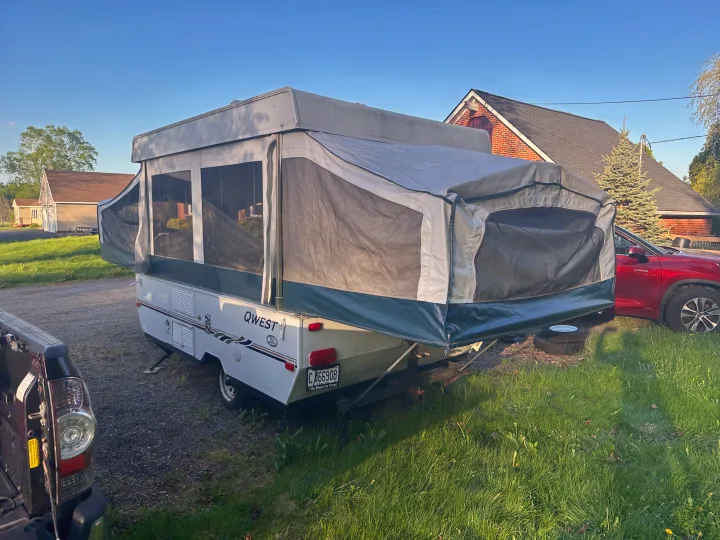 Jayco Qwest pop-up camper set up for an rv rental, with canvas sides & screened windows open, parked outside.. Jayco Qwest 2004