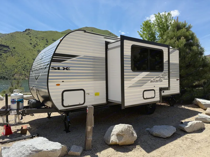 This RV rental: A Jayco travel trailer parked lakeside, ready for adventure in the mountains on a sunny day.. Jayco Jay Flight SLX Baja Edition 2025