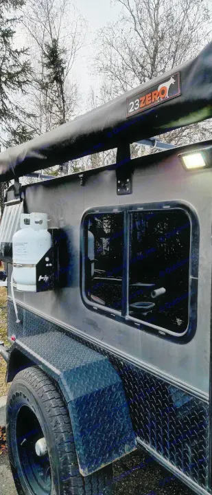 This rugged off-road utility trailer, perfect for RV rental, features a 23ZERO awning, propane tank, and side window.. Hiker Trailer Backcountry Trailer (Mid Range XL) 2022