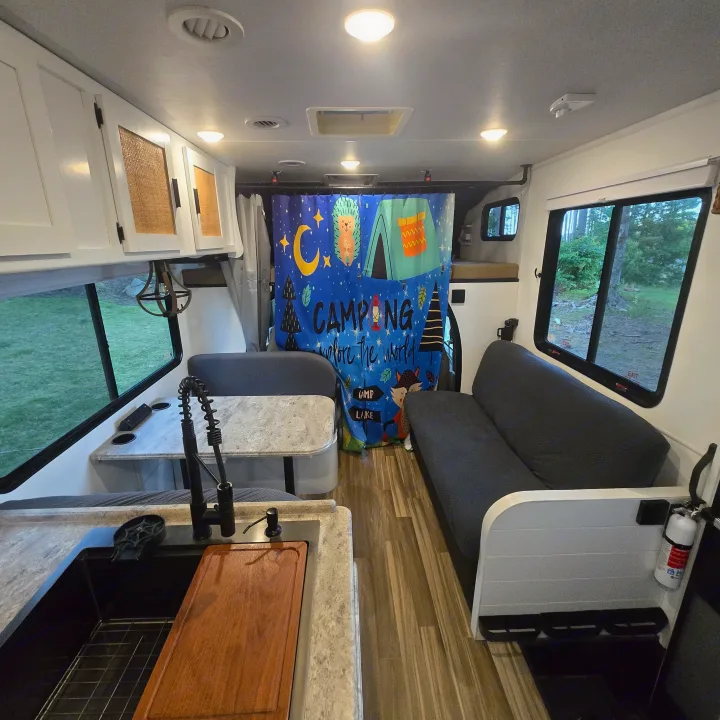 Experience comfortable travel in this rv rental featuring a kitchen, dinette, sofa, and a fun camping-themed divider.. Forest River Coachmen Freelander 2017
