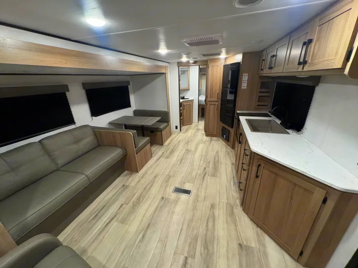 Spacious, modern RV rental interior with living area, kitchen, dinette, light wood finishes, and comfortable seating.. Keystone RV Other 2026