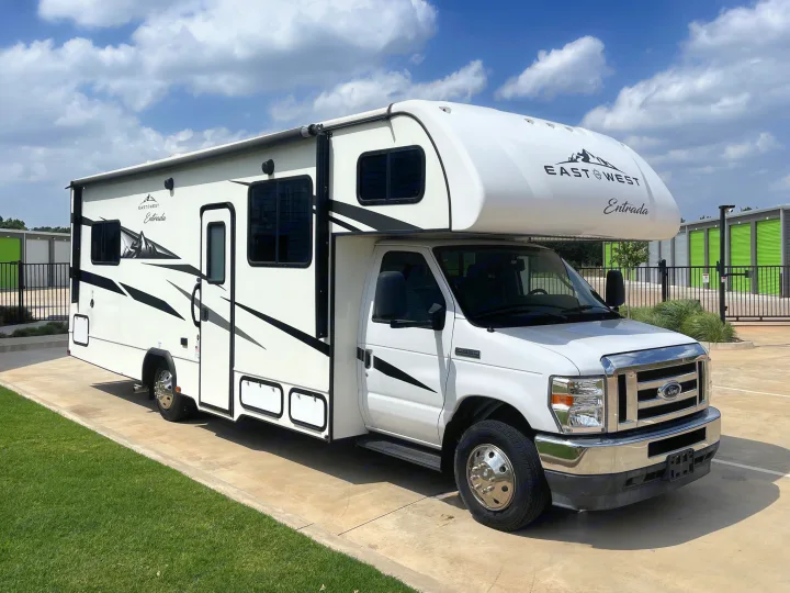 White East to West Entrada Class C rv rental, with black accents, parked on concrete. Sunny day, perfect for your next trip.. Entrada Entrada Motorhome 2022