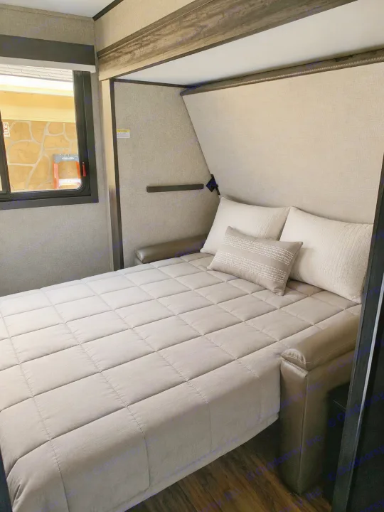 Inside an RV rental: a plush, neutral-toned sofa bed set up for a comfortable night's sleep.. Jayco Eagle HT 2022