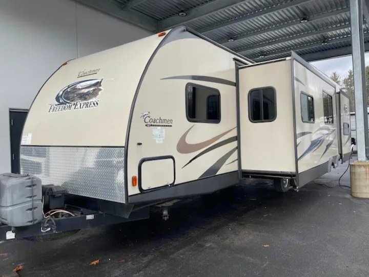 Tan Coachmen Freedom Express travel trailer RV rental, featuring an extended slide-out for extra space and comfort.. Coachmen Freedom Express 2015