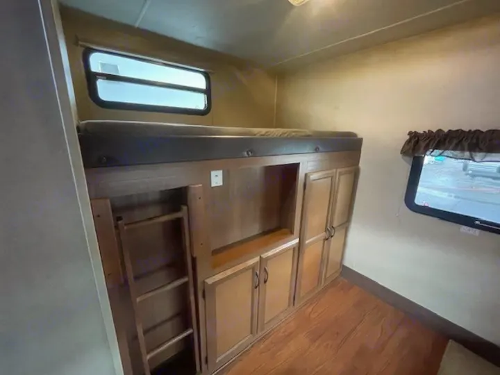 This RV rental features cozy bunk beds, built-in storage cabinets, and a convenient ladder for upper bed access.. Coachmen Freedom Express 2015