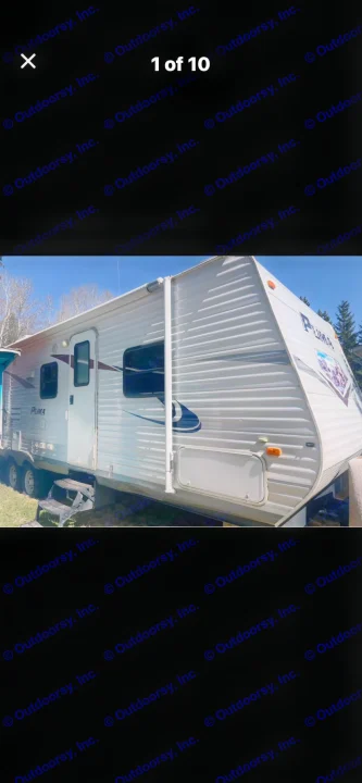 White Puma travel trailer's exterior, with door and rolled-up awning. Great for your next rv rental.. Puma Puma 2011