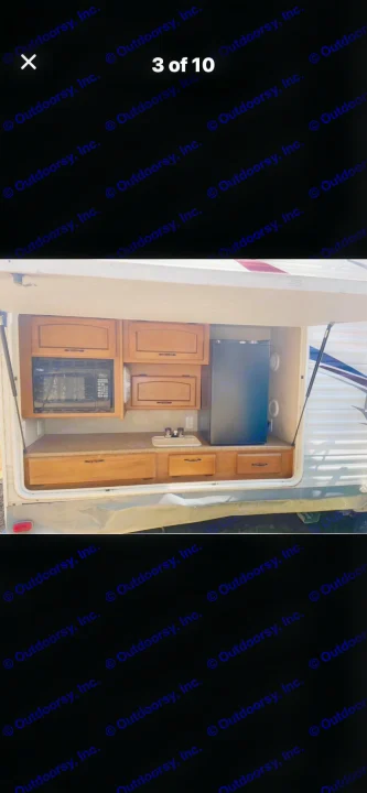 RV rental outdoor kitchen featuring a microwave, mini-fridge, and sink for convenient camping.. Puma Puma 2011