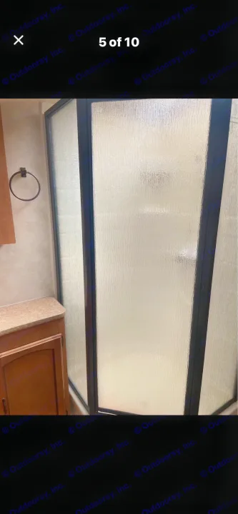 This RV rental bathroom offers a private shower stall with textured glass doors and a convenient vanity on the left.. Puma Puma 2011