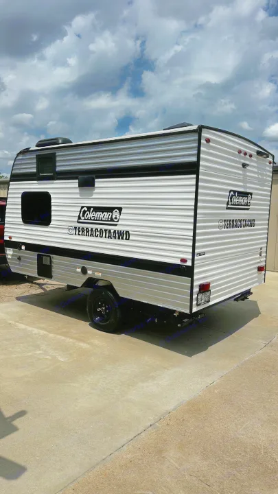 New Coleman Terracota4WD travel trailer for rv rental. Sleek white and black camper on concrete under a cloudy sky.. Keystone RV 13B travel Trailer 2026