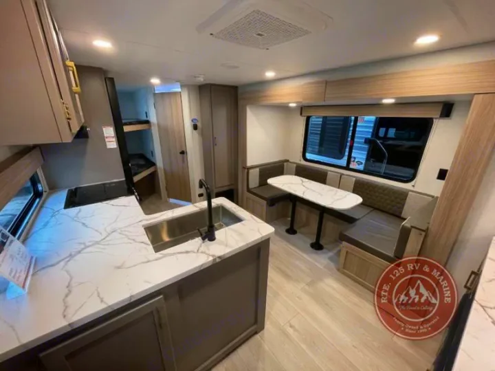 Spacious RV rental interior featuring a modern kitchen, comfortable dinette, and bunk beds. Ideal for family road trips.. KZ Sportsmen Select 2026