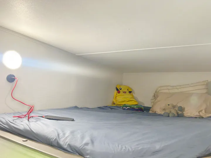 Cozy RV rental bunk bed with a bright reading light, phone charger, Pikachu, and teddy bear. A compact sleeping area.. Gulf Stream Grand River 25BH 2026