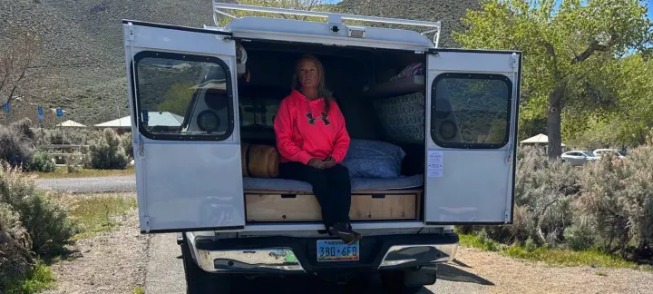 Enjoying an RV rental getaway: A woman & dog relaxing at their camper van campsite in sunny Nevada.. Ford Ford F150 2017