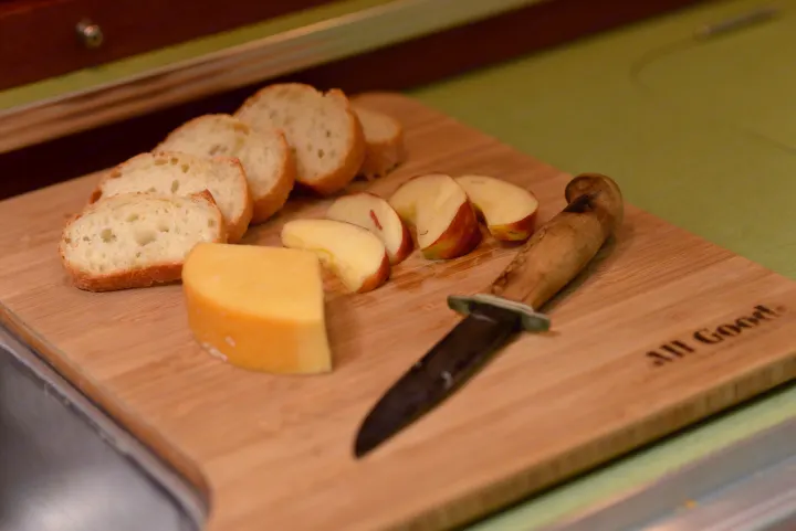 Simple delights: Cheese, apple, & bread slices on a cutting board, perfect for an easy rv rental meal.. All Good Equipment Company Teardrop Trailer 2026