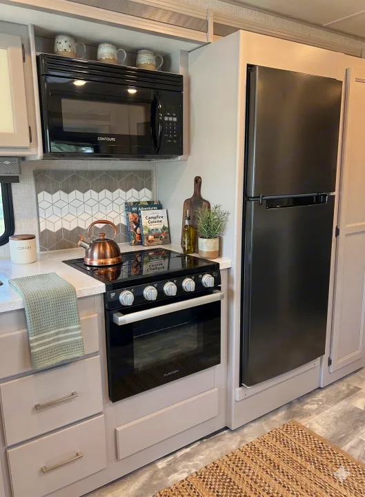 Modern RV rental kitchen with sleek appliances, including microwave, stove, oven, and fridge. Light gray cabinets & cozy decor.. Thor Motor Coach Windsport 2022
