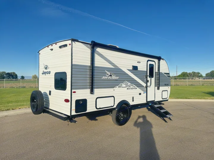 This white & grey Jayco Jay Flight Baja Edition travel trailer, ideal for an RV rental adventure, is ready for camping on a sunny day.. Jayco Jay Flight SLX 197MBW Baja 2026