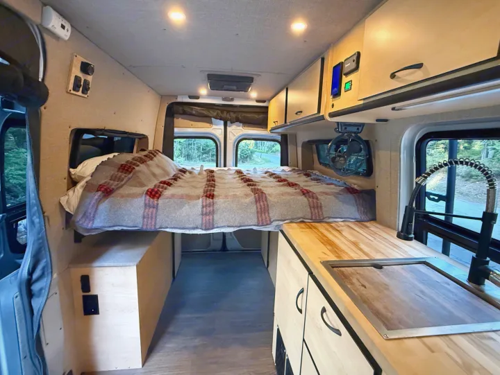 Camper van RV rental interior with a comfy bed, kitchen, overhead storage, and controls for your next adventure.. Mercedes-Benz Sprinter 2020